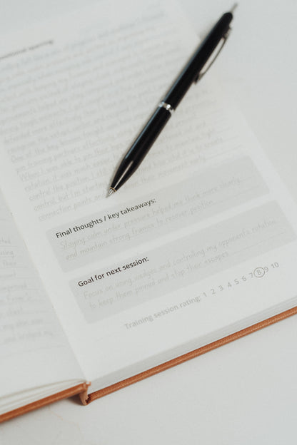Pen on an open notebook with text prompts for final thoughts and goals.