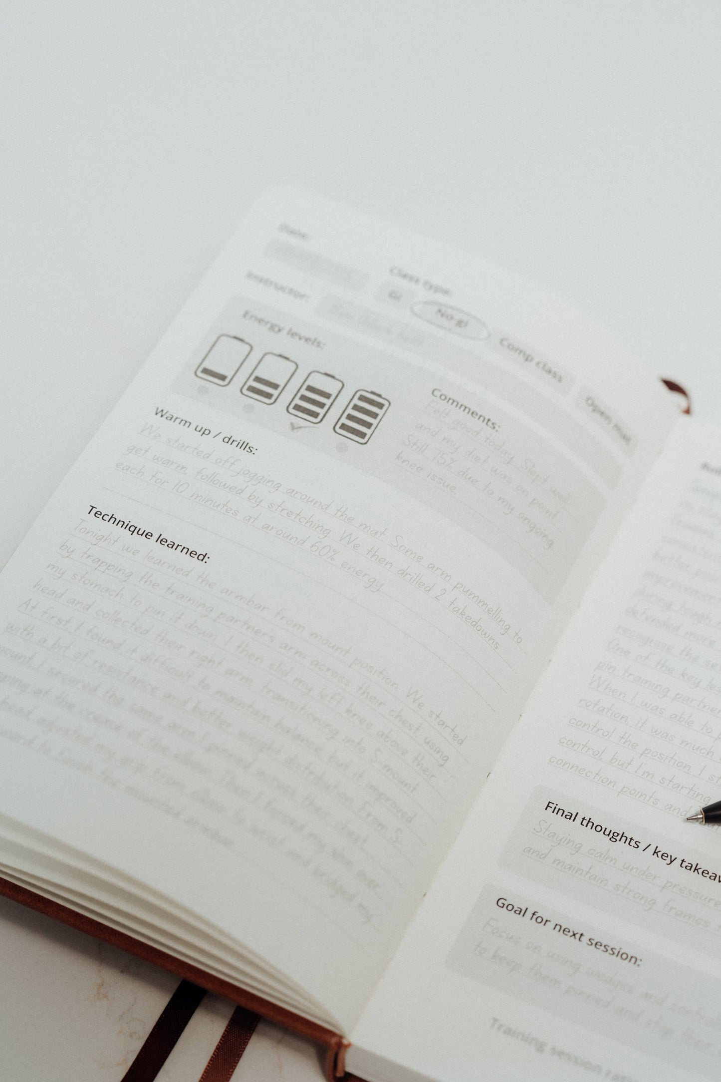 Open notebook with ivory pages and writing on a light grey background