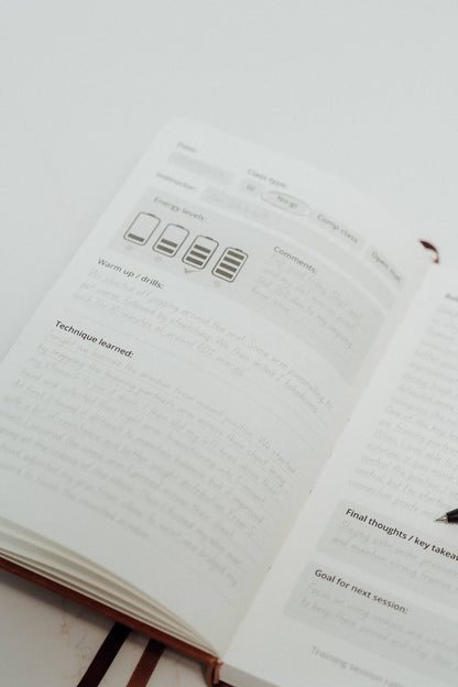 Open notebook with ivory pages and writing on a light grey background