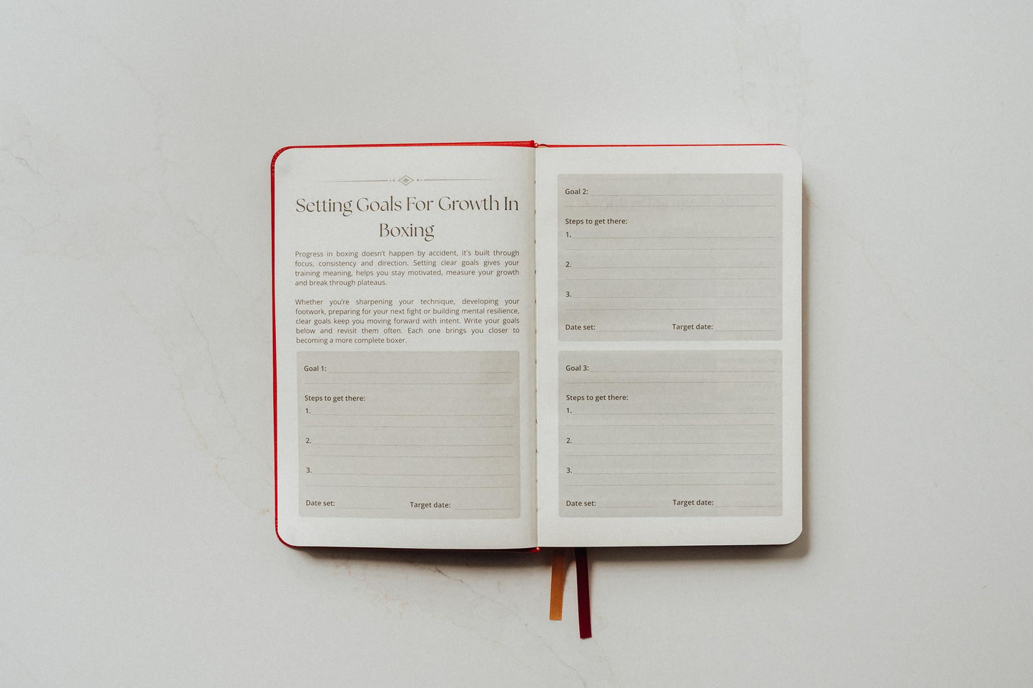 Open notebook with a page titled 'Setting Goals for Growth in Boxing' on a white background