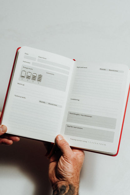 Hand holding an open notebook main page design on a light background