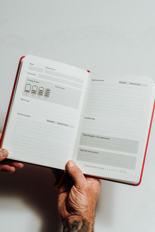 Hand holding an open notebook main page design on a light background