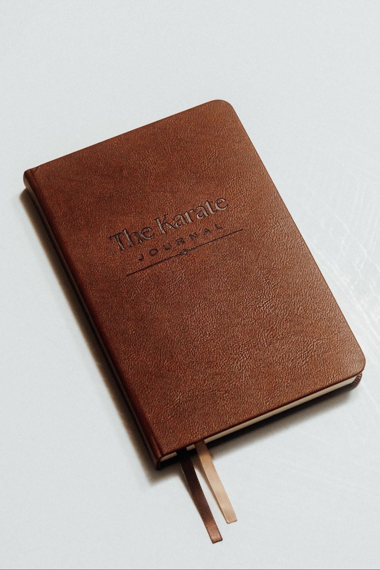 Front cover of The Karate Journal in rich brown with debossed The Karate Journal title