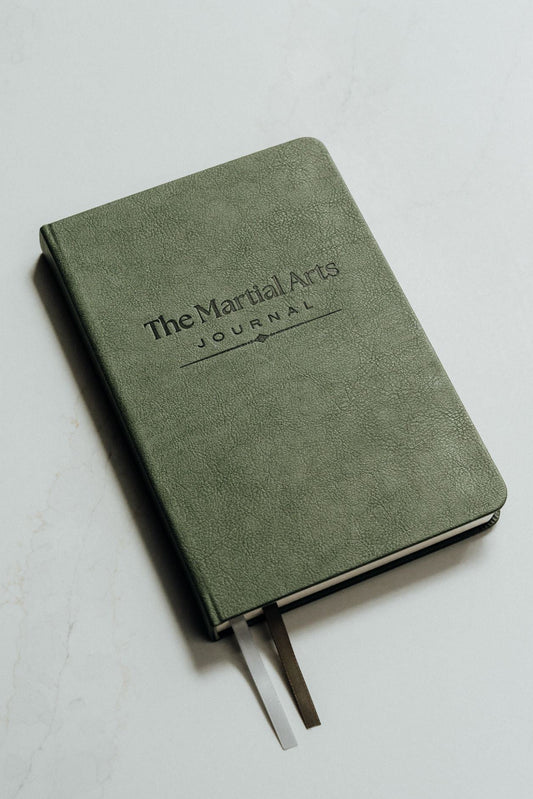 The martial arts journal in green with debossed logo set on a white background